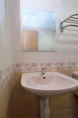 a white sink in a bathroom with a mirror at Lumut Villa Inn in Kampong Tebing Rabak