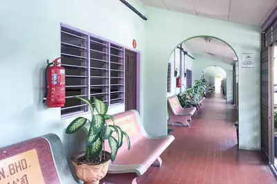 a row of benches in a waiting room with a potted plant at Lumut Villa Inn in Kampong Tebing Rabak