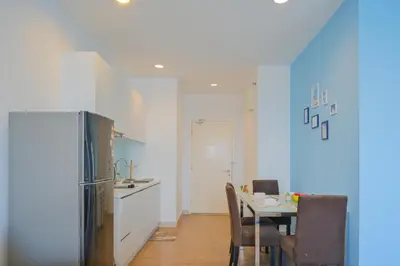 a kitchen with a table with chairs and a refrigerator at Mansion One l 4pax Studio l MountainView & CityView l Gleneagles l by PerfectSweetHome in George Town