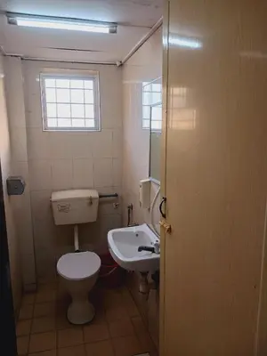 a bathroom with a toilet and a sink at Hotel Kavanass Inn in Simpang