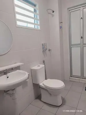 a white bathroom with a toilet and a sink at Harmoni Citra Guesthouse Bertam in Kampong Sungai Korok