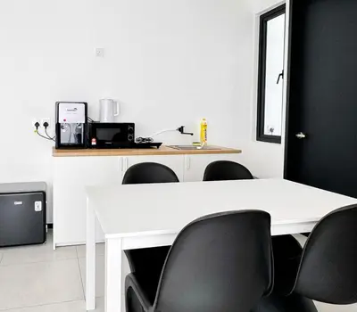 a white table with black chairs in a kitchen at Georgetown Childroom Seaview & Cityview Infinity Pool with 2 Carpark in Jelutong