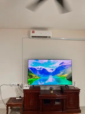 a flat screen tv sitting on top of a wooden stand at Homestay Ummi Seri Iskandar in Seri Iskandar