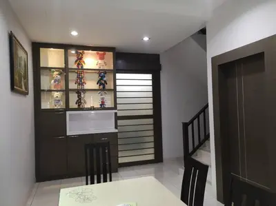 a dining room with a table and a shelf with figurines at \u4f18\u96c5\u805a\u6c11\u5bbfHome Stay in Kampong Kuala Punti