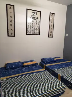 a room with three blue mattresses with oriental signs on the wall at \u4f18\u96c5\u805a\u6c11\u5bbfHome Stay in Kampong Kuala Punti