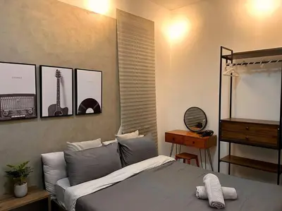 a bedroom with a bed and a table and a mirror at Urban Seaview with Infinity Pool, Luxury Modern Stylish 7pax 3Bedroom 3Queen in Jelutong