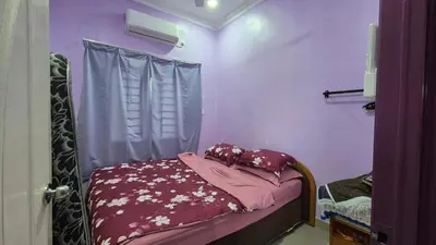 a bedroom with a bed with purple walls and a window at Sekinchan Homestay Teratak AZ - muslm only in Kampong Batu Dua Puloh Tiga