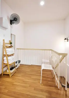 a white room with a staircase and a chair at Ipoh South Homestay 8-16pax 10mins to attraction in Ipoh
