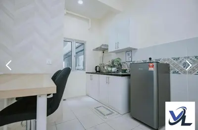 a kitchen with a table and a refrigerator at Close Dun Book in Ipoh