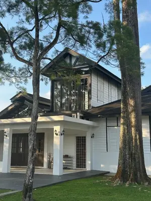 a house with two trees in front of it at The Petrichor in Tupai