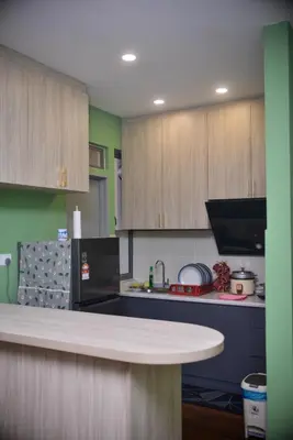 a kitchen with wooden cabinets and a counter top at Cameron Palas Homestay - Sunrise View in Brinchang