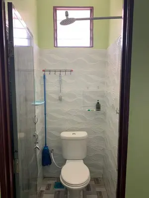 a bathroom with a toilet and a glass shower at Teratak Annur Homestay in Tanjung Karang