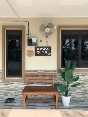 a wooden bench sitting in front of a building at Teratak Annur Homestay in Tanjung Karang