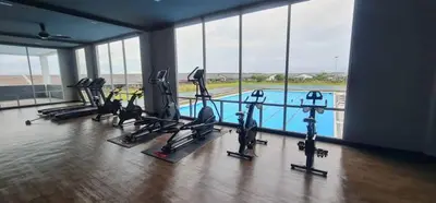 a gym with several treadmills and a swimming pool at CozyStayz Perak in Sitiawan