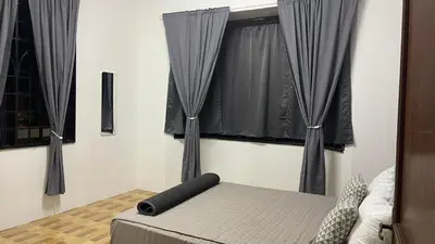 a bedroom with black curtains and a bed and a window at Homestay Rumah 25 in Sungai Petani