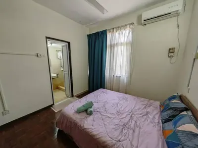 a bedroom with a bed with a purple comforter and a mirror at Bayu Emas Batu Ferringhi 2 in Ayer Itam