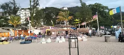 a beach with chairs and umbrellas on the sand at Sri sayang pearl view in Batu Ferringhi