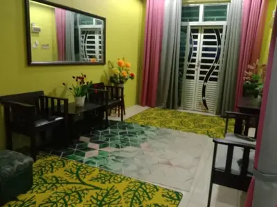 a living room with a table and chairs and a mirror at Sinakhan Homestay in Gua Musang