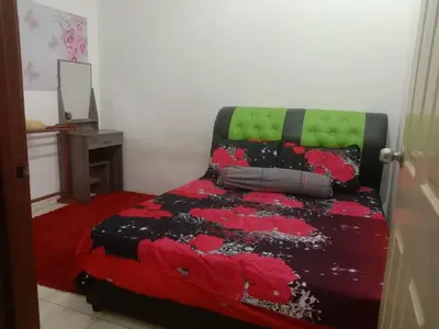 a bedroom with a bed with a red and black blanket at Sinakhan Homestay in Gua Musang