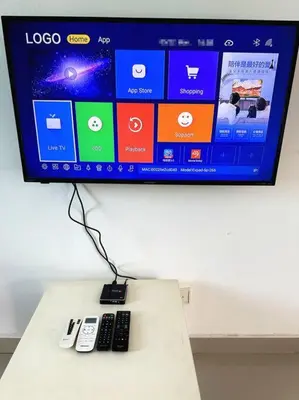 a tv with two remote controls on a table at Tur -Weeks Stay-3rooms Private House in Bayan Lepas