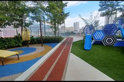 a park with two blue chairs and a bench at Perfect KTV Set & Netflix 3 Queen Bed Seaview in Jelutong