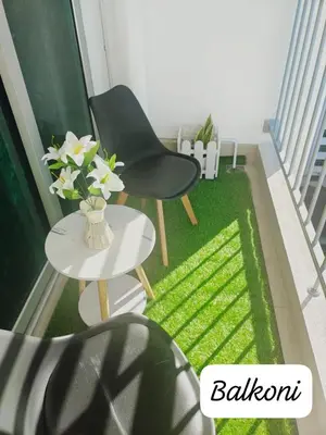 a balcony with a chair and a table with green grass at Meeymohd Homestay in Ipoh