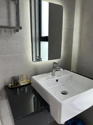 a bathroom with a white sink and a mirror at High Floor, 3BR 3queen bed, 2 parking, Urban Suites by XWHome in Jelutong
