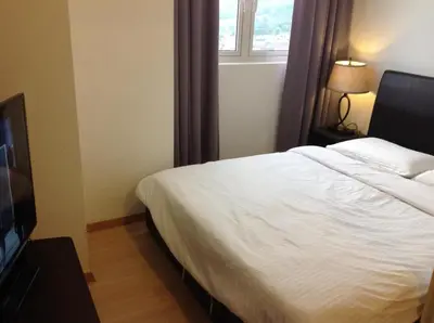 a bedroom with a white bed and a window at WenCozy 118 Vacation Home in George Town