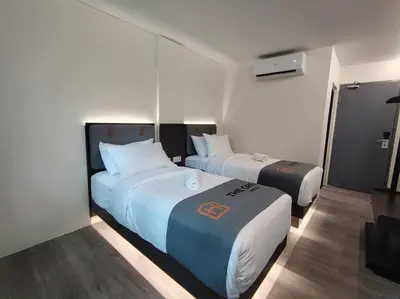 a hotel room with two beds and a television at The great hotel greenhill in Ipoh