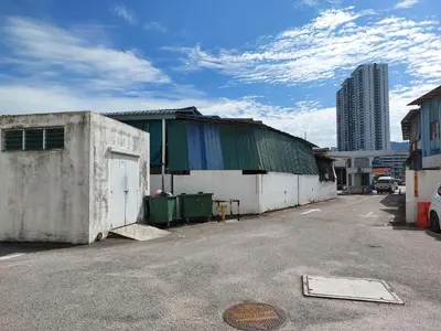 a building in a parking lot next to a street at TuR05-Pisa Stadium-3room-Private in Bayan Lepas
