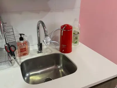 a kitchen sink with a red container next to it at Hello Kitty HomeStay - Cameron Highlands - Spacious Studio - Perfect for Families - Sleeps 4 and Baby in Tanah Rata