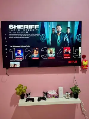 a television on a pink wall with a shelf at Hello Kitty HomeStay - Cameron Highlands - Spacious Studio - Perfect for Families - Sleeps 4 and Baby in Tanah Rata