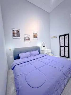 a white bedroom with a large bed with purple sheets at M & V butterworth in Butterworth