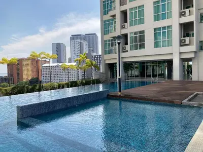 a swimming pool in front of a building with a city at Straits Garden Suites Georgetown Penang 1BRcondo in George Town