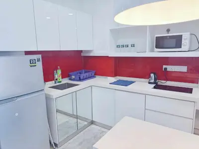 a kitchen with white cabinets and a white refrigerator at Straits Garden Suites Georgetown Penang 1BRcondo in George Town