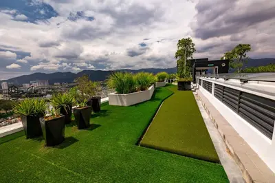 a green lawn on the roof of a building with plants at UA19 #3BR 3 Queen Bed #Family Staycation in Jelutong