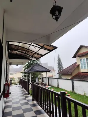 a porch with a checkered floor on a house at Bukit Cottage - bungalow style in Tanah Rata