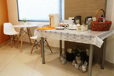 a kitchen with a table with a counter top at Big Orange Hotel Sungai Petani in Sungai Petani