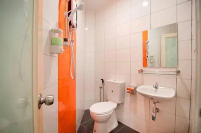 a bathroom with a toilet and a sink at Big Orange Hotel Sungai Petani in Sungai Petani