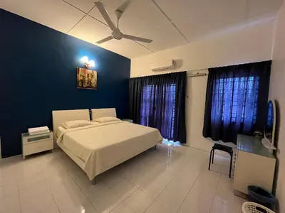a bedroom with a white bed and blue walls at Station 18 Homestay 3R3B in Ipoh
