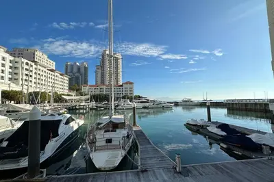 two boats are docked at a dock in a harbor at Straits Quay Highest Floor PoolView Suite in Tanjong Tokong