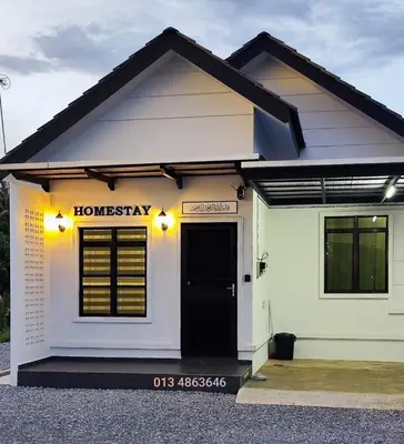 a small white building with a black door at Homestay Dataran Tikam Batu in Sungai Petani