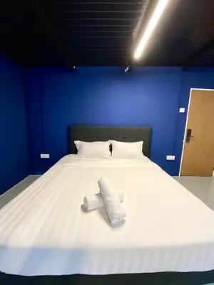 a large white bed with two towels on it at Bayu Bayu Hotel by Soft Loft in Tanjung Bungah