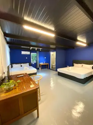 a large room with two beds and a table at Bayu Bayu Hotel by Soft Loft in Tanjung Bungah