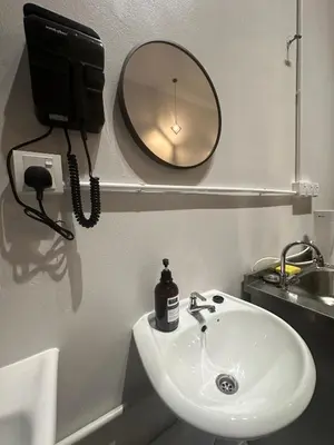 a bathroom with a sink and a mirror and a phone at Be Right Back Loft - Alma in Kampong Ayer Merah