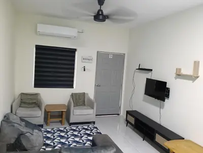 a living room with a couch and chairs and a tv at The Welcome Mat Homestay in Seri Iskandar