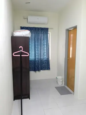 a small room with a bed and a toilet at The Welcome Mat Homestay in Seri Iskandar