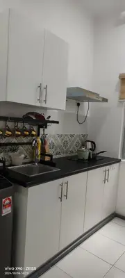 a kitchen with white cabinets and a black counter top at Ipoh Anderson Free WiFi & Tvbox 4ppl in Ipoh