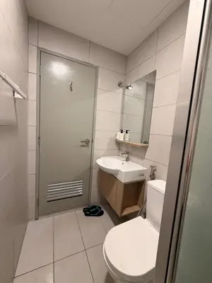 a bathroom with a toilet and a sink and a mirror at NeoSkyhigh Suites in Batu Kawan