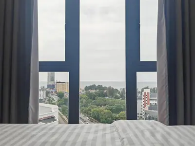 a bedroom with a bed and a view of a city at Luxe Romance with Seaview & Bathtub - Jazz Suites by Ocean Luxe in Tanjong Tokong